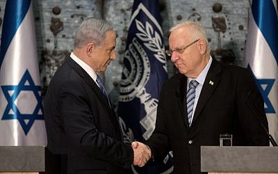 Prime Minister Benjamin Netanyahu (L) shakes hands with Israeli President Reuven Rivlin as he is formally given the task to form the next government, at the president's residence in Jerusalem on March 25, 2015. (photo credit: AFP PHOTO / MENAHEM KAHANA)