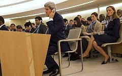 US Secretary of State John Kerry (foreground) listens to a speech on an earphone as he waits for his turn to deliver remarks to the United Nations Human Rights Council on March 2, 2015 (AFP PHOTO / POOL / EVAN VUCCI)