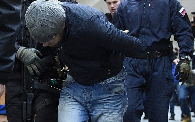 Anzor Gubashev, charged with the murder of Russian opposition figure Boris Nemtsov, is escorted by a policeman at the Basmanny district court in Moscow, on March 8, 2015. (photo credit: AFP PHOTO / DMITRY SEREBRYAKOV)