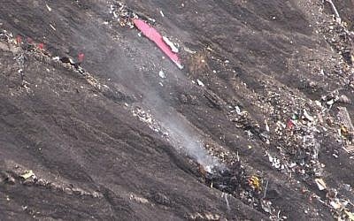 A screen grab taken from an AFP TV video on March 24, 2015 shows smoke billowing from scattered debris of the Germanwings Airbus A320 at the crash site in the French Alps above the southeastern town of Seyne. (photo credit: AFP/DENIS BOIS /GRIPMEDIA / AFP TV) 