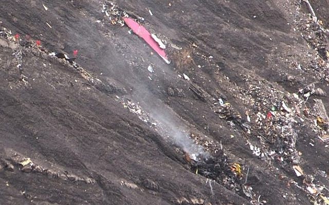 A screen grab taken from an AFP TV video on March 24, 2015 shows smoke billowing from scattered debris of the Germanwings Airbus A320 at the crash site in the French Alps above the southeastern town of Seyne. (photo credit: AFP/DENIS BOIS /GRIPMEDIA / AFP TV) 