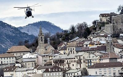 A helicopter of the French gendarmerie flies over Seyne-les-Alpes on March 28, 2015, near the site where a Germanwings flight crashed in the French Alps, killing all 150 aboard. photo credit: AFP/JEFF PACHOUD)