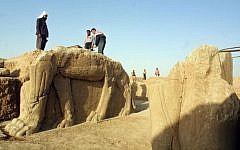 A file picture taken on July 17, 2001 shows Iraqi workers cleaning a statue of a winged bull at an archeological site in Nimrud, 35 Kilometers (22 miles) southeast of the northern city of Mosul. The Islamic State group has bulldozed the ancient Assyrian city of Nimrud in Iraq, the government said, in the jihadists' latest attack on the country's historical heritage. (photo credit: AFP/Karim SAHIB)