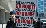 A man holds a sign outside the Washington Convention Center where Israeli Prime Minister Benjamin Netanyahu addressed the American Israel Public Affairs Committee (AIPAC) policy conference in Washington, DC, on March 2, 2015. (AFP/NICHOLAS KAMM)