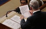 Prime Minister Benjamin Netanyahu holds up a sheet of his notes while talking about Iran during a speech to the United States Congress on March 3, 2015, in Washington, DC. (photo credit: Chip Somodevilla/Getty Images/AFP)