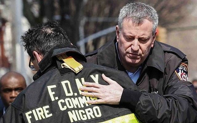 New York Mayor Bill de Blasio embraces New York's Fire Commissioner Daniel Nigro outside the house fire in the Midwood neighborhood in Brooklyn on March 21, 2015 in New York City (Photo credit: Kena Betancur/Getty Images/AFP)