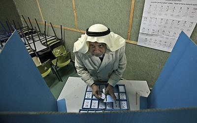 Israeli Arab Abdullah Talash, 74, chooses his ballot in order to vote in Israel's general election at a polling station in the northern Israeli Arab village of Umm Al-Fahm, February 10, 2009 (photo credit: AP/Muhammad Muheissen)