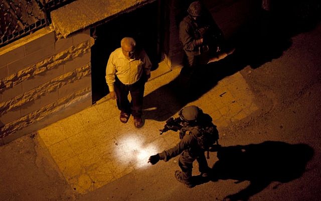In this Monday, June 16, 2014 file photo, Israeli soldiers arrest Abdel Aziz Dweik, speaker of the long-defunct Palestinian parliament and a senior Hamas figure, at his home during a military operation to search for three missing Israeli teenagers, in the West Bank city of Hebron (photo credit: AP/Majdi Mohammed)