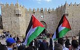 Palestinians carry national flags during a protest marking Land Day in front of the Damascus Gate in Jerusalem's Old City, Monday, March 30, 2015 (photo credit: AP/Mahmoud Illean)