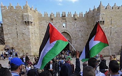 Palestinians carry national flags during a protest marking Land Day in front of the Damascus Gate in Jerusalem's Old City, Monday, March 30, 2015 (photo credit: AP/Mahmoud Illean)