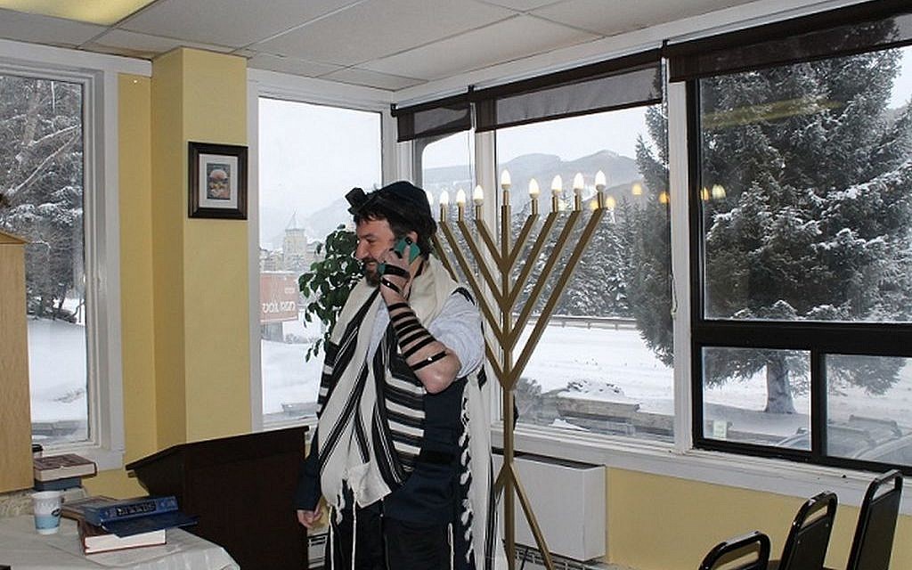 Dovid Mintz, the Chabad rabbi in Vail, Colo., works the phone trying to corral a minyan on a powdery morning at one of North America’s most popular ski towns. (Photo credit: Uriel Heilman/JTA) Dovid Mintz, the Chabad rabbi in Vail, Colo., works the phone trying to corral a minyan on a powdery morning at one of North America’s most popular ski towns. (Photo credit: Uriel Heilman/JTA)