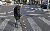 Illustrative: An elderly man crosses the street in Tel Aviv, May 20, 2009. (Serge Attal/Flash90)