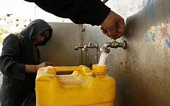 A Palestinian child fills plastic bottles and jerrycans with drinking water from a public tap at the UNRWA headquarters in the southern Gaza Strip refugee camp of Rafah, January 28, 2013 (Abed Rahim Khatib/Flash90)