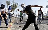 Illustrative: Palestinian youth throw stones at Israeli police during a clash in East Jerusalem, in July 2014. (Sliman Khader/Flash90)