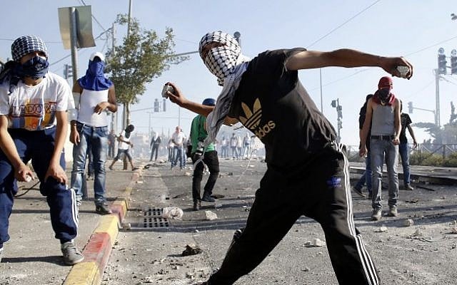 Illustrative: Palestinian youth throw stones at Israeli police during a clash in East Jerusalem, in July 2014. (Sliman Khader/Flash90)