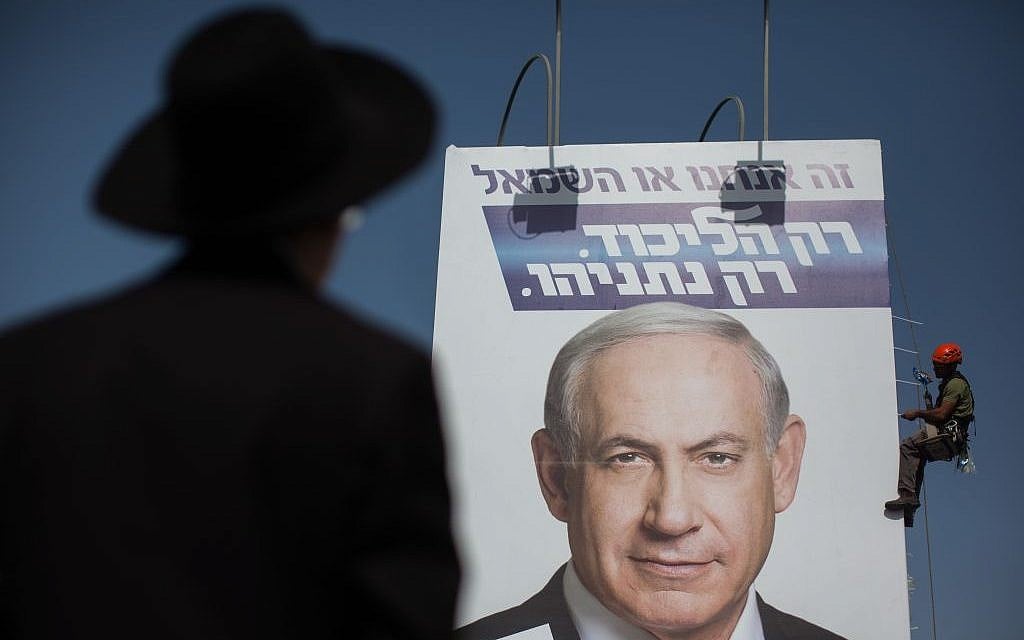 An ultra-Orthodox man looks at workers hanging a giant campaign poster showing Benjamin Netanyahu, at the entrance to Jerusalem, on March 11, 2015. (Photo credit: Yonatan Sindel/FLASH90) An ultra-Orthodox man looks at workers hanging a giant campaign poster showing Benjamin Netanyahu, at the entrance to Jerusalem, on March 11, 2015. (Photo credit: Yonatan Sindel/FLASH90)