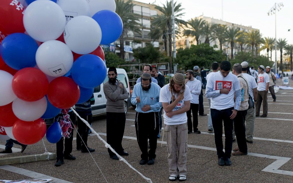 Right wing supporters seen praying before a rally in support of Prime Minister Benjamin Netanyahu, at Rabin Square in Tel Aviv on March 15, 2015. (photo credit: Ben Kelmer/Flash90)