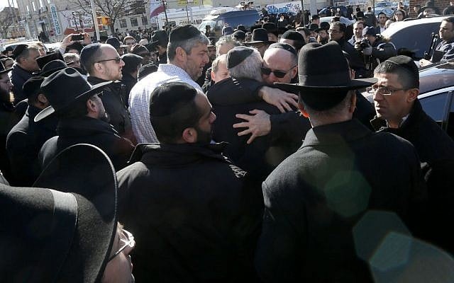 Mourners embrace each other after funeral services for the seven siblings killed in a house fire, Sunday, March 22, 2015, in the Brooklyn borough of New York. (photo credit: AP/Julio Cortez)