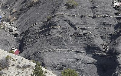 Rescue workers (at left), work at the crash site near Seyne-les-Alpes, France, on March 30, 2015. (photo credit: AP/Claude Paris, Pool)