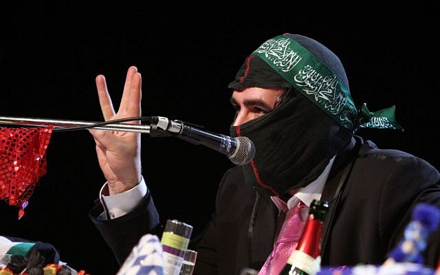 In this Saturday, March 7, 2015 photo Deniz Yucel of German newspaper 'taz' wears a mask during the 'Hate Poetry' show in the Theaterlabor in Bielefeld, Germany.  (photo credit: AP Photo/Oliver Krato)