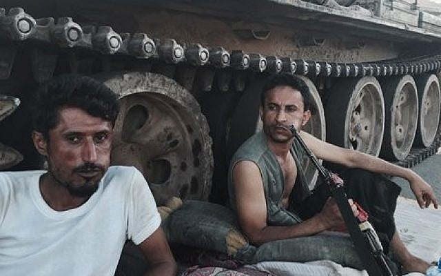 Members of a militia group loyal to Yemen's President Abed Rabbo Mansour Hadi, known as the Popular Committees, chew qat, Yemen's favorite drug, as they sit next to their tank, guarding a major intersection in Aden, Yemen, Saturday, March 21, 2015. (photo credit: AP Photo/Hamza Hendawi) Members of a militia group loyal to Yemen's President Abed Rabbo Mansour Hadi, known as the Popular Committees, chew qat, Yemen's favorite drug, as they sit next to their tank, guarding a major intersection in Aden, Yemen, Saturday, March 21, 2015. (photo credit: AP Photo/Hamza Hendawi)