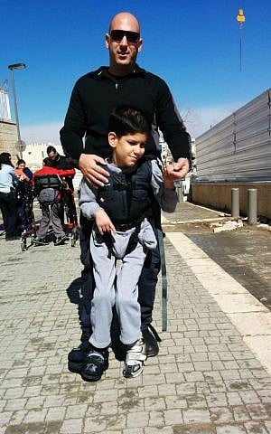 A police officer trains for the Jerusalem Marathon with an ALEH resident using an Upsee harness. (Courtesy of ALEH Jerusalem)