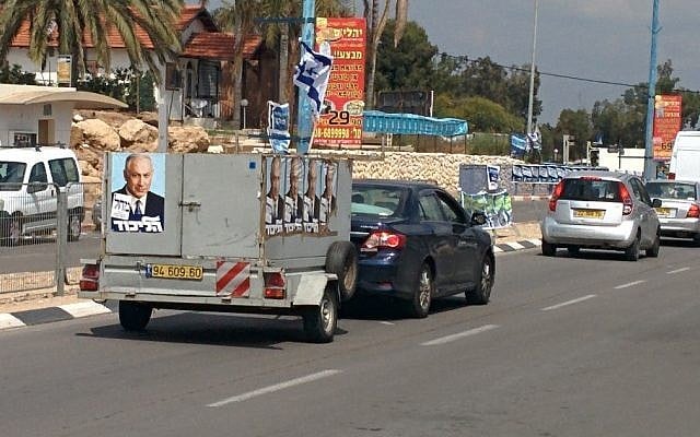 A truck with placards bearing the image of Likud party leader Prime Minister Benjamin Netanyahu drives down a street in the southern city of Sderot (photo credit: Ilan Ben Zion/Times of Israel)