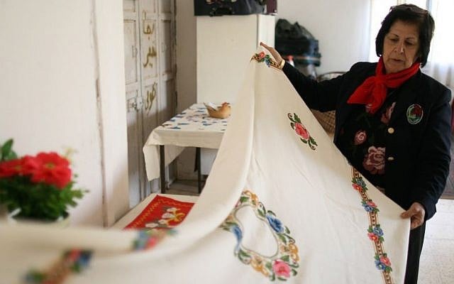Najla shows a tablecloth she embroidered for her wedding photo credit: Shaina Shealy/Times of Israel Najla shows a tablecloth she embroidered for her wedding photo credit: Shaina Shealy/Times of Israel