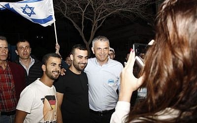 Moshe Kahlon, the Kulanu party leader, takes photographs with supporters before the polls close in South Tel Aviv on Mar. 17, 2015. (Photo credit: Judah Ari Gross/Times of Israel)