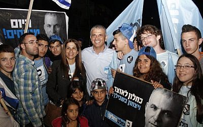 Moshe Kahlon poses with volunteers of his Kulanu party in South Tel Aviv on Mar. 17, 2015. Kahlon traveled up and down Israel's coast, rallying support before the polls close. (photo credit: Judah Ari Gross/Times of Israel)