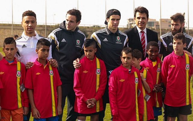 Welsh Football Team plays coexistence football with Jewish and Arab children from northern communities in Israel. The children were handed Welsh football team shirts by the players and manager Chris Coleman. R-L: Joe Ledley, Chris Coleman and Gareth Bale. (photo credit: Kobi Wolf/Courtesy)