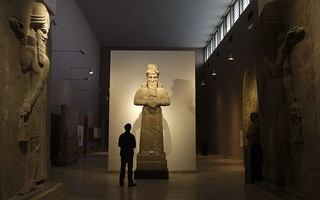 In this Nov. 24, 2009 file photo, a journalist looks at an Assyrian statue, center, in front of two Assyrian human-headed winged bulls at Iraq's national museum, in Baghdad. Islamic State militants "bulldozed" the renowned archaeological site of the ancient city of Nimrud in northern Iraq on Thursday, March 5, 2015 using heavy military vehicles, the government said. Nimrud was the second capital of Assyria, an ancient kingdom that began in about 900 B.C., partially in present-day Iraq, and became a great regional power. The city, which was destroyed in 612 B.C., is located on the Tigris River just south of Iraq's second largest city, Mosul, which was captured by the Islamic State group in June(photo credit: AP Photo/Petros Giannakouris, File)