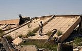 An Iraqi soldier takes photos of the demolished tomb of former Iraqi president, Saddam Hussein, in Tikrit, 130 kilometers (80 miles) north of Baghdad, Iraq, Sunday, March 15, 2015. (photo credit: AP/Khalid Mohammed)