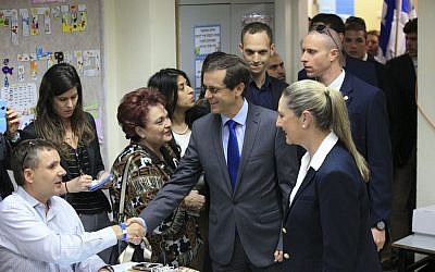Zionist Union leader Isaac Herzog accompanied by his wife Michal prepares to cast his vote in Tel Aviv, Israel, Tuesday, March 17, 2015. (photo credit: AP Photo/Ariel Schalit)