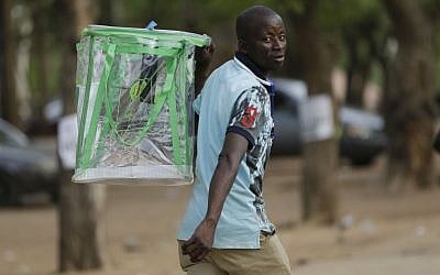 An election official walks away with an empty ballot box at the end of a vote count in one of the polling stations in Yola, Nigeria Saturday, March 28, 2015.  (photo credit: AP/Sunday Alamba) 