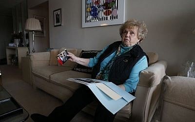 In this March 3, 2015 photo, Holocaust survivor and author Paula Burger, who is 80, sits in her living room reminiscing over photos of her children and grandchildren, in Denver. (Photo credit: AP/Brennan Linsley)