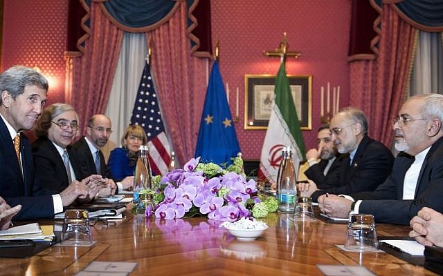 US Secretary of State John Kerry, (L) and Iranian Foreign Minister Mohammad Javad Zarif (R) wait for the start of a meeting for nuclear talks a hotel in Lausanne Switzerland, March 26, 2015. (photo credit: AP/Brendan Smialowski, Pool)