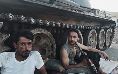Members of a militia group loyal to Yemen's President Abed Rabbo Mansour Hadi, known as the Popular Committees, chew qat as they sit next to their tank, guarding a major intersection in Aden, Yemen, March 21, 2015 (AP Photo/Hamza Hendawi, File)