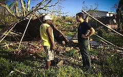 An IsraAid worker speaks with a local man after Cyclone Pam battered the Pacific Island nation of Vanuatu in March 2015. (photo credit: IsraAID)