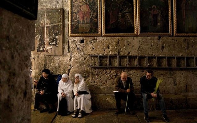 Christian worshipers gather at the Church of the Holy Sepulchre, traditionally believed by many to be the site of the crucifixion and burial of Jesus Christ, during Palm Sunday in Jerusalem's Old City, Sunday, March 29, 2015. (photo credit: AP Photo/Oded Balilty) 
