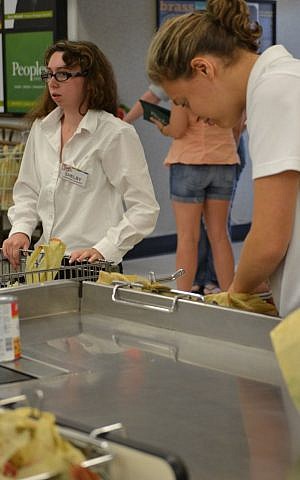 Rachel Palmer (right) and Shelby Marcus bag groceries at Trig's (Courtesy of Ramah Wisconsin/JTA)