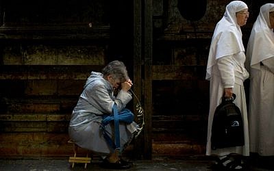 Christian worshipers gather at the Church of the Holy Sepulchre, traditionally believed by many to be the site of the crucifixion and burial of Jesus Christ, during Palm Sunday in Jerusalem's Old City, Sunday, March 29, 2015. (photo credit: AP Photo/Oded Balilty)