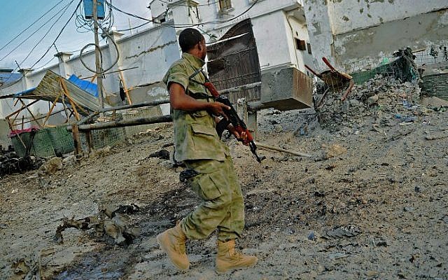 A soldier walks past at the scene of a car bomb attack and armed raid by Shebab terrorists on the Maka al Mukarama hotel in Mogadishu on March 27, 2015 (photo credit: AFP) A soldier walks past at the scene of a car bomb attack and armed raid by Shebab terrorists on the Maka al Mukarama hotel in Mogadishu on March 27, 2015 (photo credit: AFP)