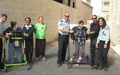 Police officers from Jerusalem's Lev Habira station  and ALEH residents take a break from their training for the Jerusalem Marathon. (courtesy of ALEH Jerusalem)