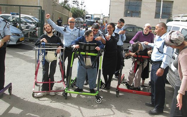 Israeli police officers from Jerusalem's Lev Habira station help residents of ALEH train to 'run' the Jerusalem Marathon in their walkers. (Courtesy of ALEH Jerusalem)