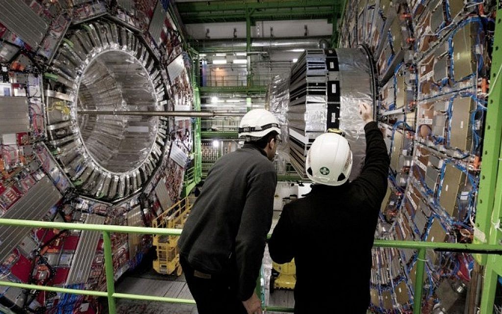 A Picture taken on February 10, 2015 shows workers in front of the CMS (Compact Muon Solenoid) Cavern at the European Organization for Nuclear Research (CERN) in Meyrin, near Geneva. The world's biggest particle collider was back in operation on April 5, 2015 after a two-year upgrade. (Photo credit: Richard Juilliart/AFP)