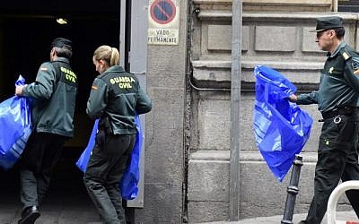 Spanish Civil Guard workers, carrying evidence and effects seized from people suspected of links to the Islamic State, arrive at the Spanish National Court in Madrid on April 10, 2015. (AFP/Gerard Julien)