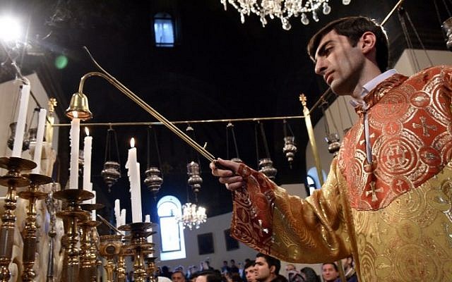 A cleric puts out a candle during a religious service at the cathedral in Etchmiadzin, outside Yerevan, on April 23, 2015, ahead of the canonization ceremony for the Martyrs of the Armenian Genocide. (Photo credit: Karen Minasyan/AFP) A cleric puts out a candle during a religious service at the cathedral in Etchmiadzin, outside Yerevan, on April 23, 2015, ahead of the canonization ceremony for the Martyrs of the Armenian Genocide. (Photo credit: Karen Minasyan/AFP)