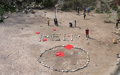 Foreign trekkers and Nepalese guides are pictured alongside a 'HELP' sign constructed with white stones, from an Indian Army helicopter at Machha Khola, in northern-central Gorkha district on April 29, 2015.  (photo credit: AFP/SAJJAD HUSSAIN)