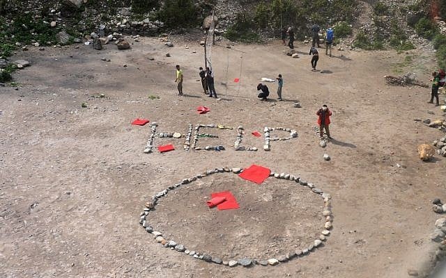 Foreign trekkers and Nepalese guides are pictured alongside a 'HELP' sign constructed with white stones, from an Indian Army helicopter at Machha Khola, in northern-central Gorkha district on April 29, 2015. (photo credit: AFP/SAJJAD HUSSAIN) Foreign trekkers and Nepalese guides are pictured alongside a 'HELP' sign constructed with white stones, from an Indian Army helicopter at Machha Khola, in northern-central Gorkha district on April 29, 2015. (photo credit: AFP/SAJJAD HUSSAIN)